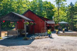 a red barn with a bench in front of it at Deer Den cottage in Huntsville in Huntsville