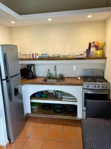 a small kitchen with a sink and a stove at Hotel Condominium La Posada de Bucerias in Bucerías