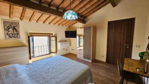 Schlafzimmer mit einem Bett, einem Tisch und einem Fenster in der Unterkunft La Casa del Corso in Arcidosso