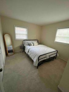 1 dormitorio con cama y espejo. en Beautiful New Everything 3BD House in Hayfield, en Alexandria