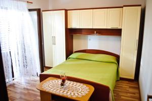 a bedroom with a green bed and a table at House Iliskovic in Hvar