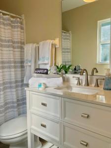 a bathroom with a sink and a toilet and a mirror at WALK TO BEACH: 3BR home with spacious backyard in Jacksonville Beach