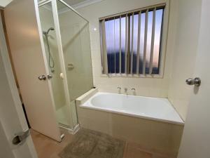 bagno con vasca, doccia e finestra di 5 Beds-Whole House-Carrum Beach- Patterson Lake-Fully Furnished a Carrum Altre 25 foto