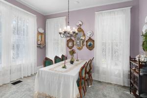 a dining room with a white table and chairs at Ross Mansion Bed & Breakfast in Hattiesburg