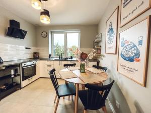 a kitchen with a table and chairs and a kitchen with a sink at Closer Place in Tomaszów Mazowiecki