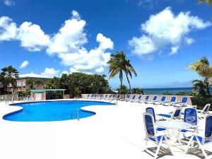 a swimming pool with chairs and a table at St Croix Bliss - Tranquil Retreat-Ocean Views-Island Breezes in Christiansted