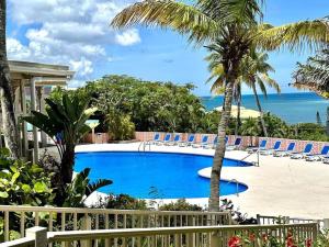 una piscina con sillas y el océano en el fondo en St Croix Bliss - Tranquil Retreat-Ocean Views-Island Breezes en Christiansted