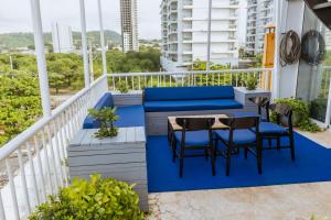 een balkon met een blauwe bank en tafels en stoelen bij King's Apartments 302 in Cartagena