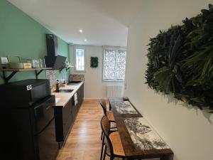 a kitchen with a table and a dining room at STUDIO JUNGLE - HYPEr CENTRE LORIENT in Lorient