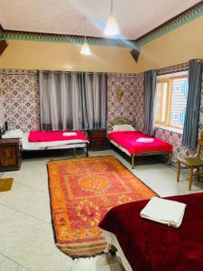 1 Schlafzimmer mit 2 Betten und einem Teppich in der Unterkunft MAISON D'HOTES IRIKI in Tinghir