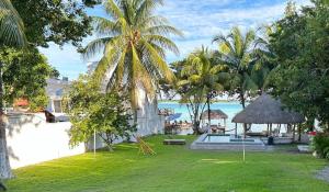 a resort yard with a pool and palm trees at Casa Tarimoro-Bacalar in Bacalar