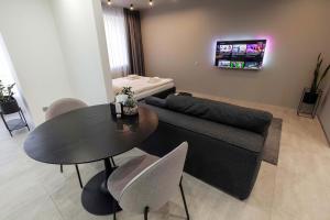 a living room with a couch and a table with chairs at Cactus Apartments 2 in Ivano-Frankivsʼk