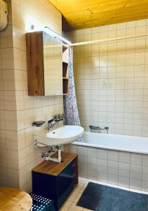 a bathroom with a sink and a bath tub at Alpenresidenz - CharmingStay in Flumserberg