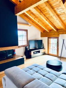 sala de estar con sofá y TV en Alpenresidenz - CharmingStay, en Flumserberg