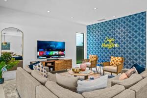 uma sala de estar com um sofá e uma televisão em Heated Saltwater Pool, Arcades, Golf - 5min to Las Olas Boulevard em Fort Lauderdale