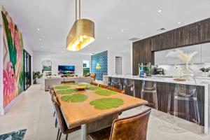 uma cozinha e sala de jantar com uma mesa de madeira e cadeiras em Heated Saltwater Pool, Arcades, Golf - 5min to Las Olas Boulevard em Fort Lauderdale