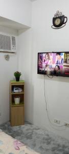 Elle comprend une télévision à écran plat suspendue au mur. dans l'établissement AURORA STAYCATION, à Manille