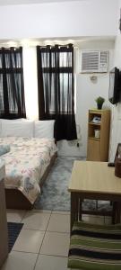 - une chambre avec 2 lits et une table dans l'établissement AURORA STAYCATION, à Manille