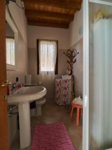 baño con lavabo blanco y ventana en Agriturismo Fondo Novelle La Casina, en Ferrara