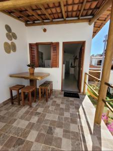 d'une terrasse avec une table et des chaises en bois. dans l'établissement NOVO Chalé Pôr do Sol Canoa Quebrada, à Aracati