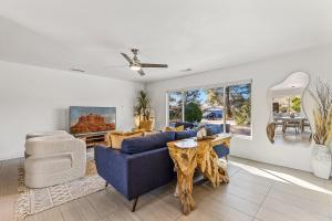 uma sala de estar com um sofá azul e uma mesa em Trendy 3BR in Sedona: Hot Tub/Fire-pit /Central Location em Sedona