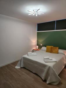 a bedroom with a large bed with a green wall at CASA CLEO in Udine