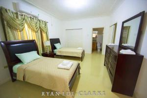 1 dormitorio con 2 camas, tocador y espejo en Shan's Manor.... Excellent Location!!! en Kingston