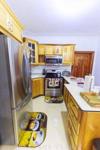 uma cozinha com armários de madeira e um frigorífico de aço inoxidável em Shan's Manor.... Excellent Location!!! em Kingston