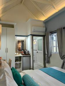 1 dormitorio con 1 cama y cocina. en Villa Charme de L'ile, en La Réunion