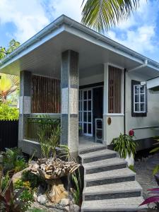 una pequeña casa blanca con escaleras delante en Villa Charme de L'ile, en La Réunion