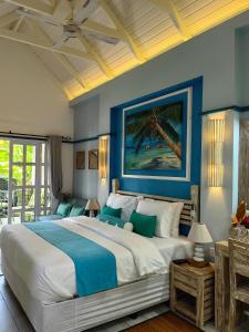 1 dormitorio con 1 cama grande y paredes azules en Villa Charme de L'ile, en La Réunion