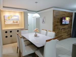 ein Esszimmer mit einem weißen Tisch und Stühlen in der Unterkunft Double Beach - Um cantinho inesquecível da Praia do Morro, lugar de tranquilidade e mar calmo in Guarapari