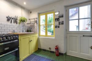 a kitchen with yellow cabinets and a stove at Chez Miriam - Maison de caractère - Ville avec jardin in Montrichard