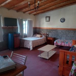 a bedroom with a bed and a table and a tv at Mecohue in Villa Giardino
