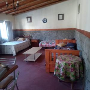 a bedroom with two beds and a table and chairs at Mecohue in Villa Giardino