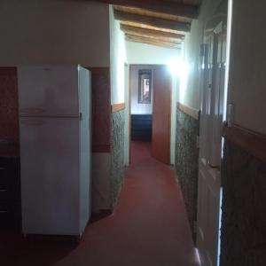 um corredor com um frigorífico branco num quarto em Mecohue em Villa Giardino