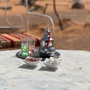 a table with two bowls of food and a drink at Sahara Ousis Camp in Merzouga