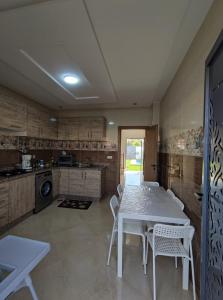 eine Küche mit einem Tisch und Stühlen im Zimmer in der Unterkunft Chalet villa QUE POUR LES FAMILLES in Imouzzer du Kandar