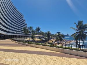 una acera junto a una playa con un edificio en Ondina Apart Hotel, en Salvador