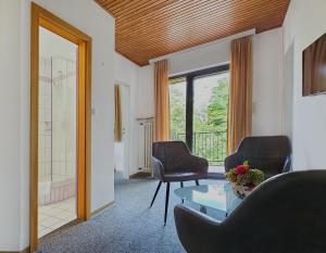 a living room with two chairs and a glass table at Vintage Hotel Petrisberg in Trier