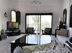 a living room with a couch and a coffee table at Lovely Villa Amelkis One Marrakech in Marrakech