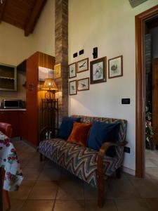 una sala de estar con sofá y algunas fotos en la pared en Agriturismo Fondo Novelle La Casina, en Ferrara