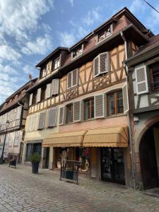 - un grand bâtiment dans une rue pavée dans l'établissement Les Myrtilles, à Barr