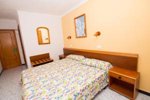 a bedroom with a bed and a desk at Hotel Amic Can Pastilla in Can Pastilla
