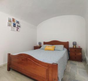 a bedroom with a wooden bed and a night stand at Old Évora Hostel in Évora