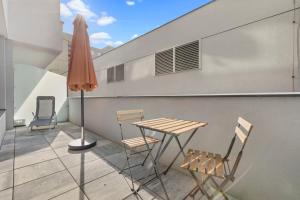 ブラチスラヴァにあるLAM Yacht Club - TERRACE 10m2のテーブルと椅子と傘のあるパティオ