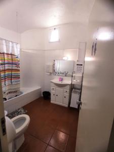 a white bathroom with a toilet and a sink at Old Évora Guest House in Évora