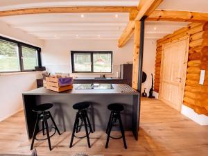 uma cozinha com um balcão e bancos num quarto em Pur Natur! Wandern und Skifahren - Trahütti Premium Lodges em Trahütten