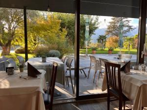 ein Restaurant mit Tischen und Stühlen und einem großen Fenster in der Unterkunft Hotel Raffl in Bozen