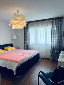 1 dormitorio con 1 cama, 1 silla y 1 ventana en Steinbock - CharmingStay, en Flumserberg